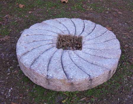 This millstone is 53 inches in diameter and 8 inches thick. It weighs 1,629 pounds more than ¾ of a ton.